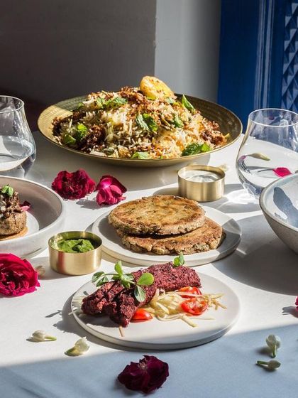 Sunlight streams over a table laden with our innovative Indian dishes, highlighting the fresh ingredients and beautiful colors of our food.