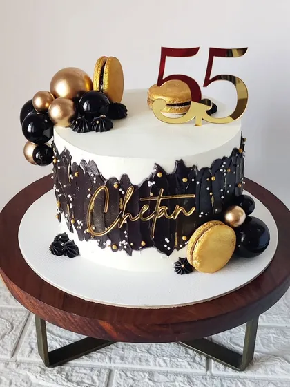 Another angle of the sophisticated 55th birthday cake, displayed on a wooden stand that complements its modern design.