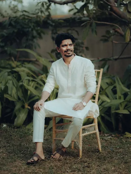 A relaxed portrait of Abhishek. Seated in a garden, he looks away thoughtfully, creating a candid and natural feel.