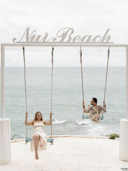 The couple enjoying the iconic swings at Nui Beach in Phuket.