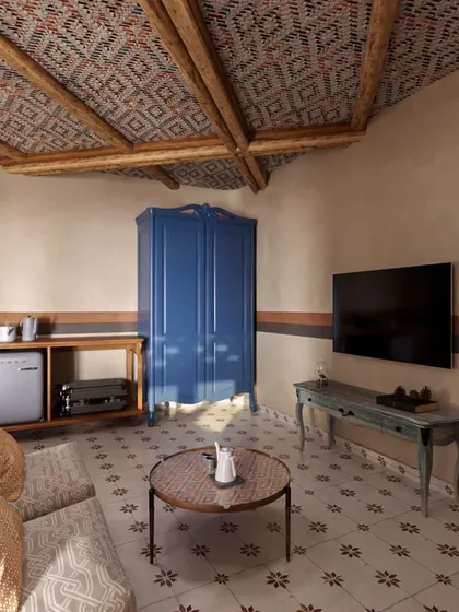 This living area within a suite features a vibrant blue armoire as a statement piece. It demonstrates how I use bold color sparingly to add personality and focus within a predominantly neutral and earthy palette.