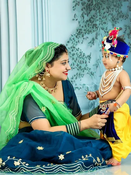 Celebrating Janmashtami with a special Krishna-themed photoshoot. Here, a mother shares a loving look with her son, who is beautifully dressed as little Krishna, complete with traditional attire and jewelry.