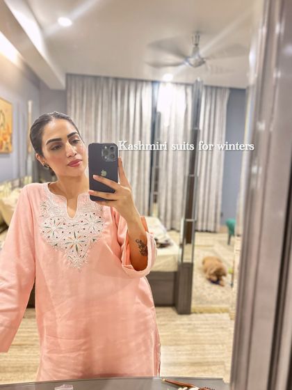A mirror selfie showing a lovely peach Kashmiri suit. The delicate white embroidery around the neckline makes it a beautiful piece for casual festive gatherings.