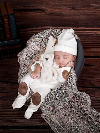 Another wide shot of a vintage setup, this time with a baby in a sleeper cap and footed pajamas, creating a slightly different but equally charming look.