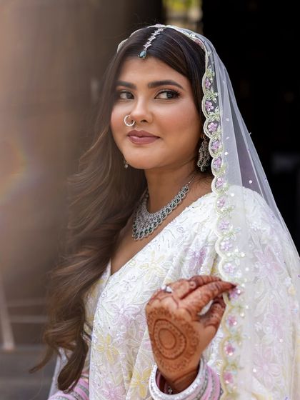 A profile shot showing the delicate details of her veil and the simple, elegant makeup.