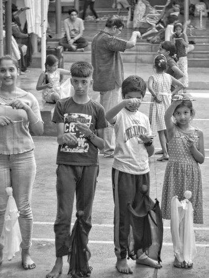 A line of children and young adults, each holding the puppet they made. Our workshops are for all ages, and it's wonderful to see everyone learning together.