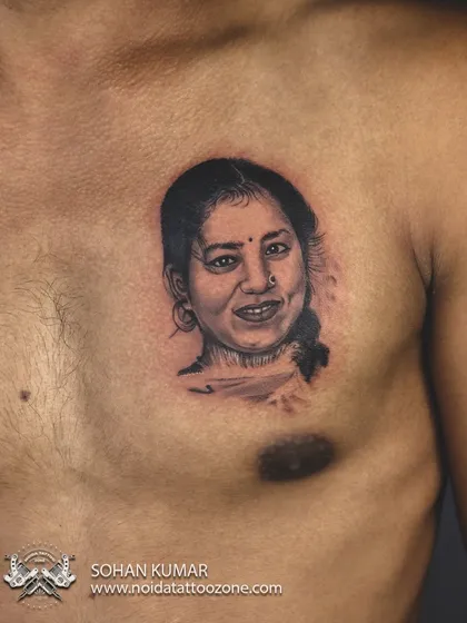 A finished portrait tattoo on the chest. The soft shading and precise details in the face create a realistic and moving tribute to a loved one.