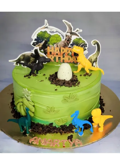 A Jurassic Park theme cake that's roaring with flavor. This eggless chocolate truffle cake is decorated with non-edible dinosaur toys and edible cookie crumble dirt for a prehistoric adventure.