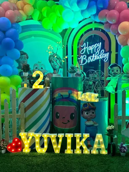 A full frontal view of the Cocomelon party stage, showcasing the symmetry of the balloon arches and the placement of the characters.