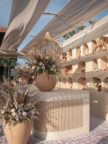 The bar area was also part of the theme. I used dried grasses, pampas, and neutral-toned flowers in large earthen pots, with a custom-built bar featuring fluted details and arched niches.
