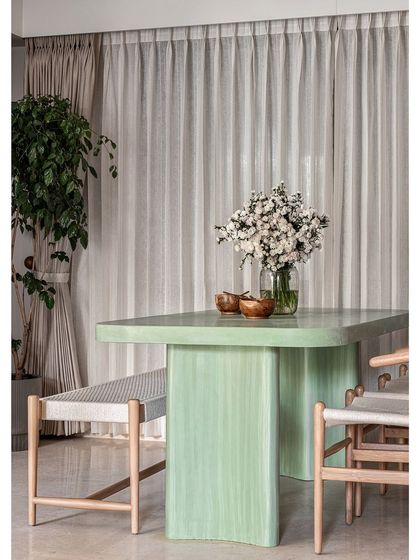 This green dining table makes a statement. After exploring many materials, we chose concrete for its unique feel. The most tedious task was getting the color right, but after countless samples, we landed on this gorgeous green that anchors the dining space perfectly.