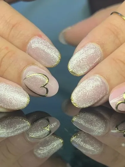 A romantic design with sparkling glitter nails and nude accent nails featuring a delicate gold heart outline.