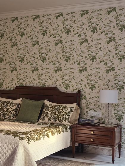 A closer look at the master bedroom's details. The floral wallpaper and embroidered linen from Sarita Handa bring the garden's texture and color palette indoors, creating a cohesive, nature-inspired design.