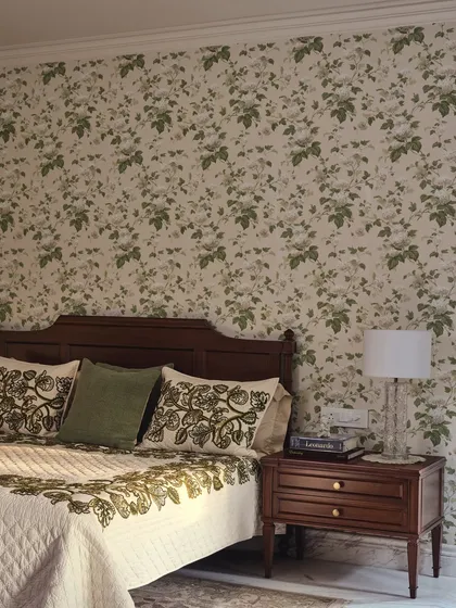 A closer look at the master bedroom's details. The floral wallpaper and embroidered linen from Sarita Handa bring the garden's texture and color palette indoors, creating a cohesive, nature-inspired design.