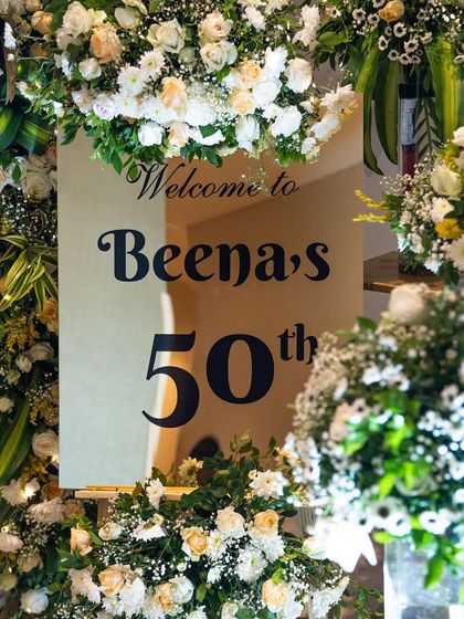 The welcome sign for Beena's 50th was a beautiful focal point. Surrounded by lush flowers, it was the perfect way to honor her and welcome guests to the surprise celebration.