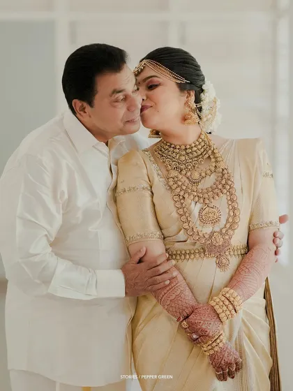 A touching moment between the bride and her father, his kiss on her cheek a gesture of love and blessing.