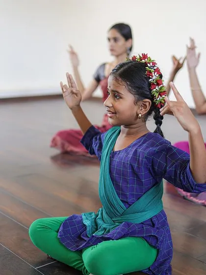 Young dancers practicing their seated postures and hand gestures with smiles on their faces. I believe learning should be a happy and fulfilling experience.