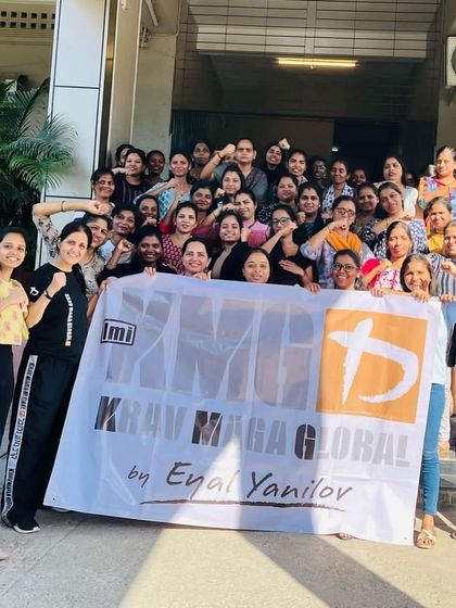 Participants from a large logistics company in India holding the KMG banner after their women's self-defense workshop. Group photos like this capture the sense of community and shared achievement from our sessions.