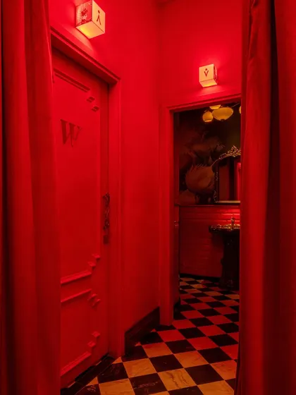 The corridor to the restrooms, where the immersive red continues. The design ensures that even transitional spaces are part of the overall brand experience.