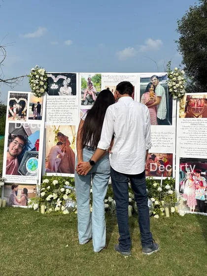 The newly engaged couple admiring the wall of memories I created for their proposal. This personalized backdrop tells their love story through photos and handwritten notes.