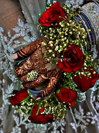 A close-up of the engagement henna stain with red roses.