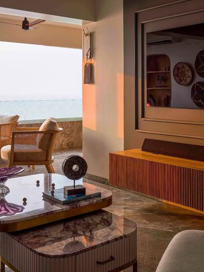 This living room opens up to a beautiful sea-facing balcony. I used layered coffee tables and comfortable seating to create a space where you can enjoy the view from both indoors and out.