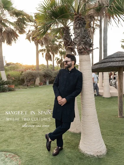 Sangeet in Spain, where two cultures dance as one. The groom's classic Indian attire looks perfectly at home against the backdrop of palm trees, showcasing our expertise in styling for destination weddings.