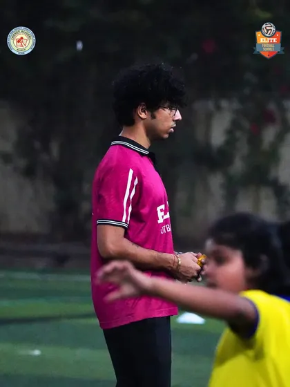 A coach observing the game, a constant presence guiding our young players.
