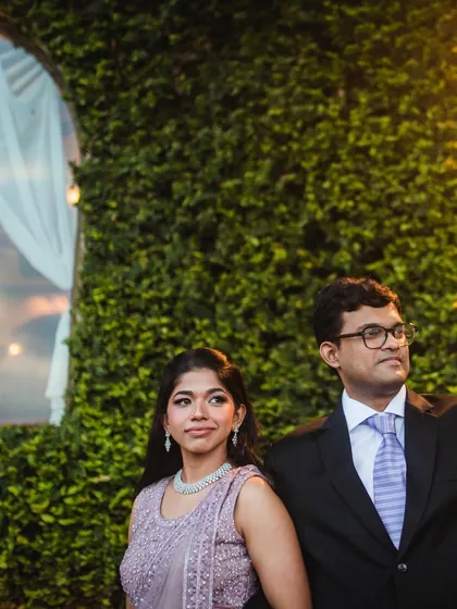 A stylish portrait of the couple at their reception. The lush green wall and warm lighting provide a beautiful backdrop for this evening shot.