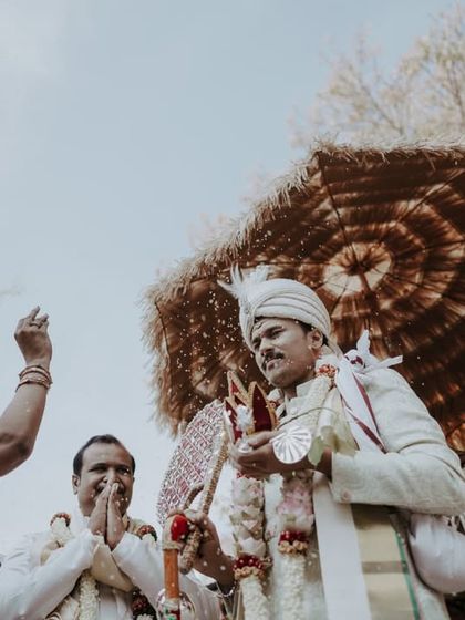 A low-angle shot of the groom during the Kashi Yatre ritual, surrounded by his family.