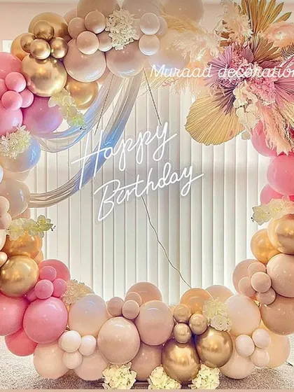 This circular balloon installation is a modern and elegant choice for birthdays, anniversaries, or bridal showers. I mix different sizes of chrome gold, pastel pink, and nude balloons, and weave in dried pampas grass for texture. The custom "Happy Birthday" neon sign makes it a perfect centerpiece.