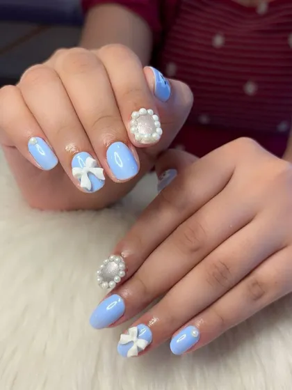 The coquette nail trend is here to stay. This set features a dreamy baby blue base with hand-crafted 3D bows and intricate pearl frame details for a super cute and classic look.