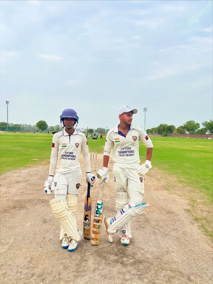 Our Zone. Two batsmen in the middle of the pitch, a picture of focus and partnership.