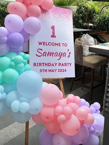 A personalized welcome sign for a Cocomelon themed first birthday party. The sign is framed with a beautiful pastel balloon garland, setting the tone for the celebration right from the entrance.