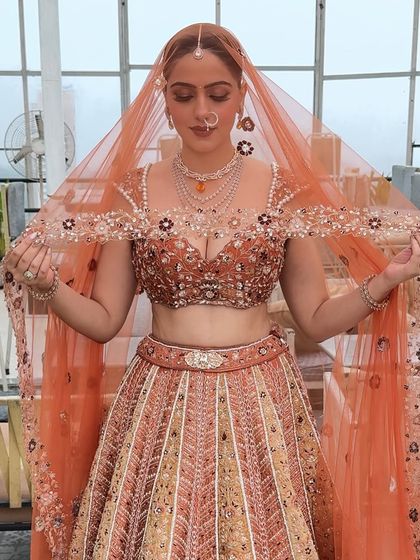 The bride adjusting her beautiful embroidered dupatta. This candid moment shows how the makeup stays perfect even while she moves.