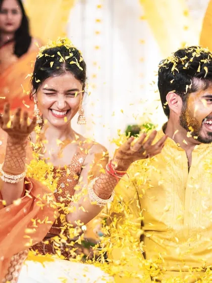The couple playfully throwing petals at each other during their haldi.