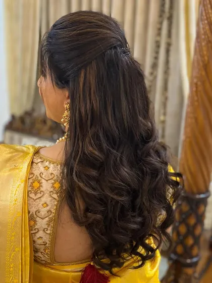 A simple and elegant half-updo with soft waves and subtle highlights. This is a perfect hairstyle for a bride who wants a natural and understated look.