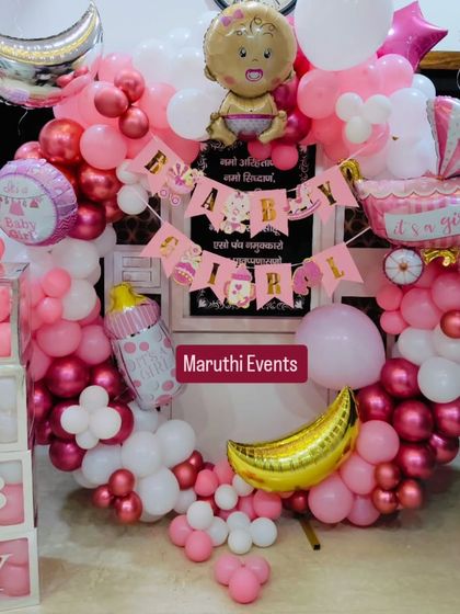 A full and festive 'Baby Girl' welcome ceremony decoration. The pink and white balloon ring is filled with details like a baby carriage, a milk bottle, and 'BABY' blocks.