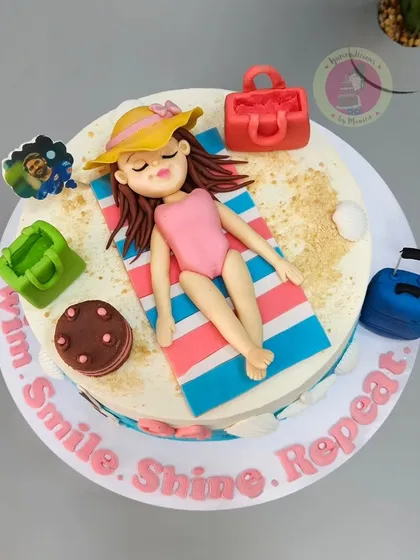 Vacay mode on! This beach-themed cake features a relaxing fondant figure, sandy textures made from brown sugar, and tiny, detailed accessories like luggage and shopping bags.