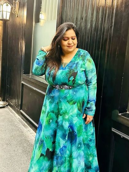 Style is about expressing who you are. This client radiates confidence in her custom-made floral georgette gown, which features a flattering V-neck and an embellished belt to accentuate the waist.