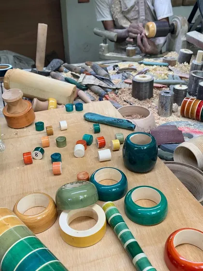 The artisan's workshop is filled with colorful wooden components in various stages of completion. This scene captures the vibrant energy and meticulous labor that goes into creating each piece for our custom installations.