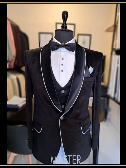 This black velvet tuxedo features elegant white piping along the lapels and pockets, adding a subtle yet striking contrast to the classic silhouette.