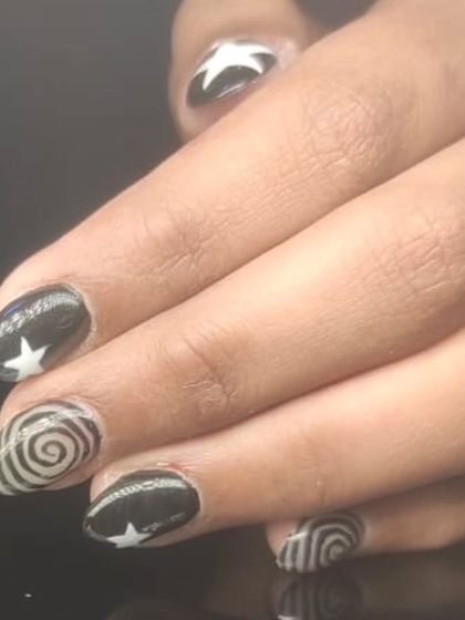 A close-up of the graphic star and swirl nail art.