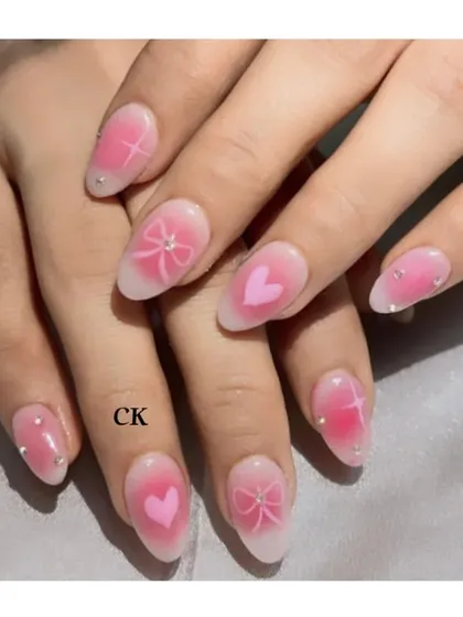 This is one of my favorite new techniques, airbrush nail art. I created this dreamy look with a soft pink gradient, adding cute hearts, bows, and star designs. The tiny rhinestone accents give it a final touch of sparkle.