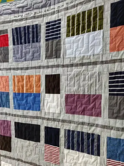A memory quilt made from t-shirts, with handwritten messages quilted into the border for an extra personal touch.