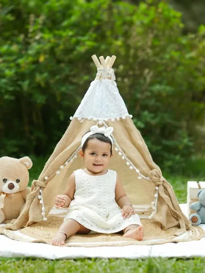 A simple and sweet outdoor first birthday setup. The focus is all on her adorable expression and the classic props.