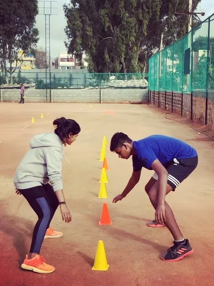 Advanced players participate in an agility and reaction drill using cones. My competitive program includes intensive fitness conditioning to improve on-court speed and stamina.