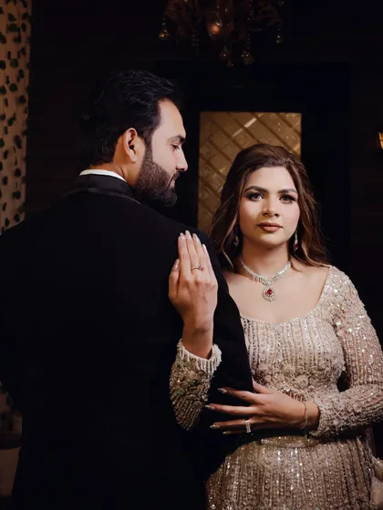 A stylish and moody portrait of the couple. The groom looks over his shoulder at the bride, creating a sense of drama and romance in this engagement shot.