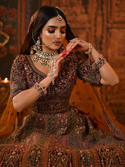 A close-up on the intricate details of the lehenga and the bride's hands, adorned with beautiful jewelry.