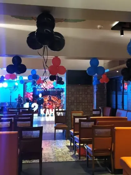 The full view of an Avengers-themed birthday party venue. We decorated the entire space with hanging balloon bunches in red, blue, and black to match the main stage setup.
